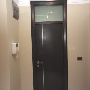 Furnirana nefalcovana vrata, profilisan pervajz, fiksno nadsvetlo sa staklom koje je peskirano po detalju, krilo vrata sa aluminijumskom lajsnom