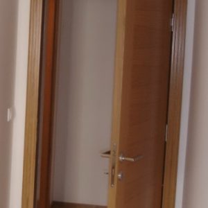 Furnirana nefalcovana vrata, profilisan pervajz, ravno krilo sa dve bočne vertikale furnira i zasebno fiksno nadsvetlo iznad vrata