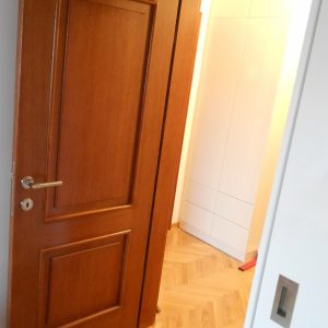 Furnirana nefalcovana vrata, ravan pervajz, krilo vrata sa dve profilisane ispune i dva vertikalna sloga furnira sa strane